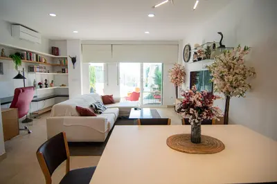 a living room with a table and a couch at Casa PLAYA FONTANILLA in Conil de la Frontera