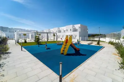a playground with a slide in front of a building at Casa PLAYA FONTANILLA in Conil de la Frontera