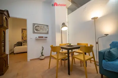 a living room with a dining room table and chairs at El Anfitrión - Palacio XVIII in Sanlúcar de Barrameda