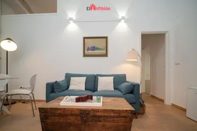 a living room with a blue couch and a coffee table at El Anfitrión - Palacio XVIII in Sanlúcar de Barrameda