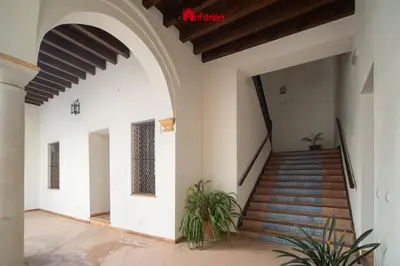 a staircase in a house with an archway at El Anfitrión - Palacio XVIII in Sanlúcar de Barrameda