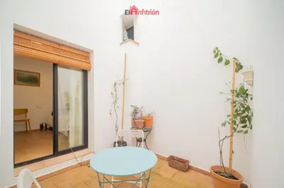 a white room with a table and some plants at El Anfitrión - Palacio XVIII in Sanlúcar de Barrameda
