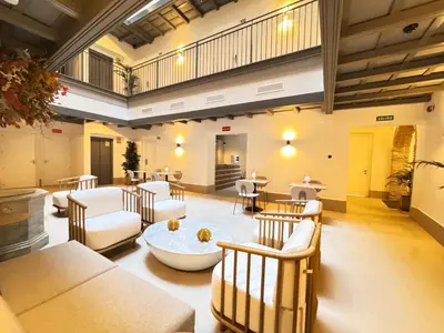 a large living room with chairs and tables at La Caleta QE Hotels in Cádiz