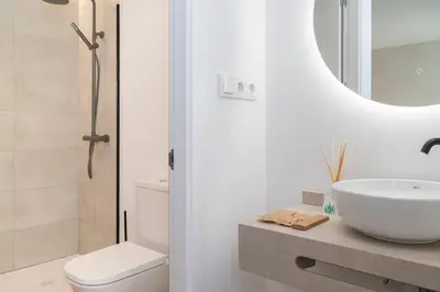 a bathroom with a sink and a toilet and a mirror at La Caleta QE Hotels in Cádiz