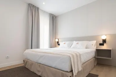a bedroom with a large white bed and a window at La Caleta QE Hotels in Cádiz