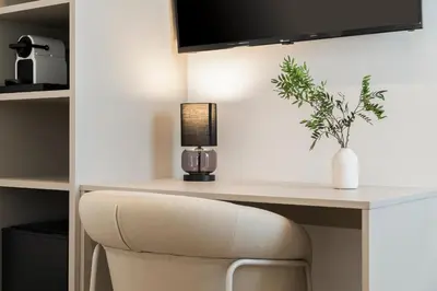 a desk with a chair with a lamp and a plant at La Caleta QE Hotels in Cádiz