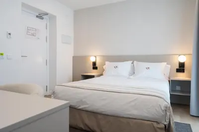 a bedroom with a large bed with white sheets and pillows at La Caleta QE Hotels in Cádiz