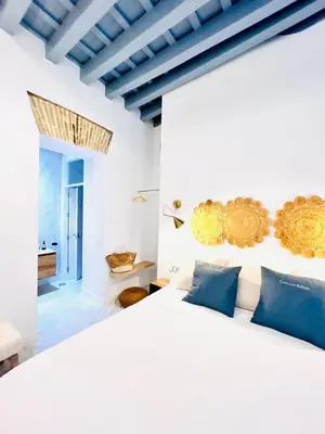 a bedroom with a white bed with blue pillows at inncadiz Los Balbos apartment in Cádiz