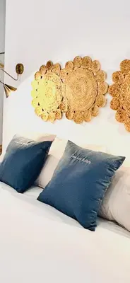a white bed with blue pillows and a gold headboard at inncadiz Los Balbos apartment in Cádiz