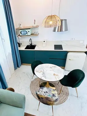 a kitchen with a table and two chairs and a sink at inncadiz Los Balbos apartment in Cádiz