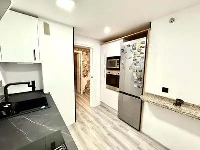 a kitchen with white cabinets and a stainless steel refrigerator at alsur by Staycare in Jerez de la Frontera