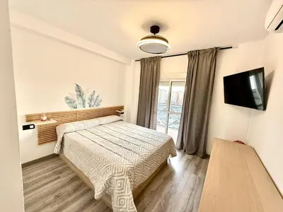 a bedroom with a bed and a flat screen tv at alsur by Staycare in Jerez de la Frontera