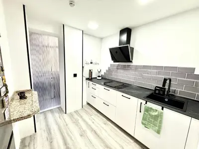 a kitchen with white cabinets and black counter tops at alsur by Staycare in Jerez de la Frontera