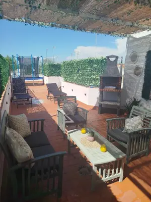 a patio with chairs and a table and a stove at Brisa&Mar, con Posibilidad de Parking in Chipiona