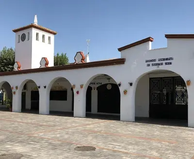 a white building with arches and a clock tower at Brisa&Mar, con Posibilidad de Parking in Chipiona