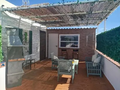 a patio with chairs and tables and a pergola at Brisa&Mar, con Posibilidad de Parking in Chipiona