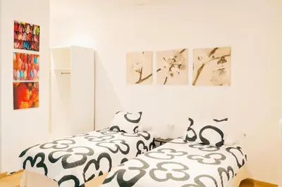 a bedroom with two beds with black and white sheets at Check-in autónomo Centro Histórico Todo a pie Ideal para parejas in Jerez de la Frontera