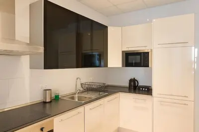 a kitchen with white cabinets and a sink at Check-in autónomo Centro Histórico Todo a pie Ideal para parejas in Jerez de la Frontera