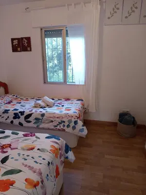 a bedroom with two beds and a window at Mi Rinconcito de El Manantial in El Puerto de Santa María
