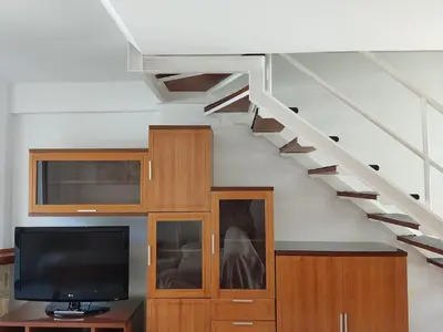 a living room with a tv and a staircase at Mi Rinconcito de El Manantial in El Puerto de Santa María