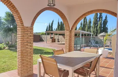 a patio with a table and chairs in a yard at Villa Ureba in Conil de la Frontera