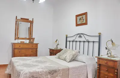 a bedroom with a bed and two dressers and a mirror at Villa Ureba in Conil de la Frontera
