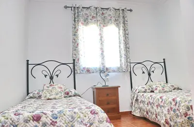 two beds in a room with a window at Villa Ureba in Conil de la Frontera