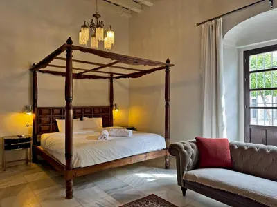 a bedroom with a canopy bed and a couch at Palacio Jaramago - Ole Solutions in Jerez de la Frontera