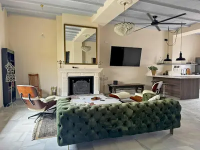a living room with a green couch and a fireplace at Palacio Jaramago - Ole Solutions in Jerez de la Frontera