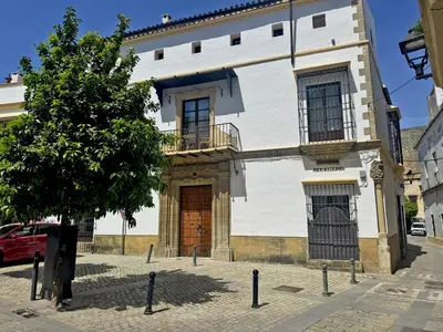 a white building with a tree in front of it at Palacio Jaramago - Ole Solutions in Jerez de la Frontera