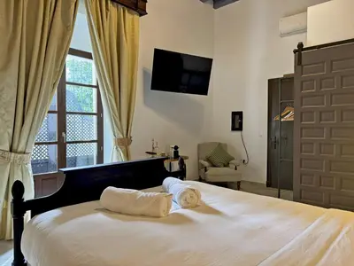 a bedroom with a bed with two pillows and a window at Palacio Jaramago - Ole Solutions in Jerez de la Frontera