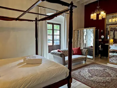 a bedroom with a bed and a chair and a mirror at Palacio Jaramago - Ole Solutions in Jerez de la Frontera