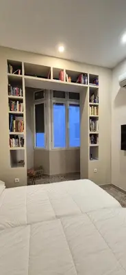 a bedroom with a large white bed and bookshelves at Santa Catalina by Gades Gestión in Cádiz