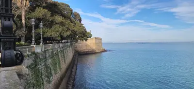 a stone wall next to a body of water at Santa Catalina by Gades Gestión in Cádiz