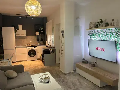 a living room with a television on a wall at Apartamento Sol y Playa in Rota