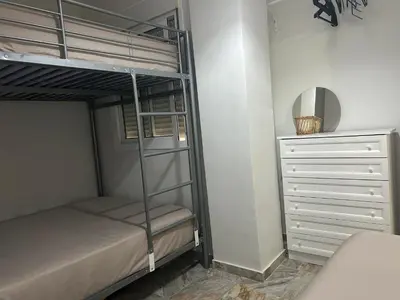a bedroom with a bunk bed and a dresser at Apartamento Sol y Playa in Rota