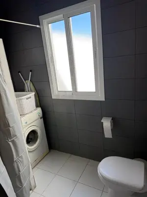 a bathroom with a washing machine and a window at Apartamento con piscina y jardín in Chiclana de la Frontera