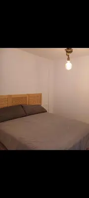 a bedroom with a large bed with a light on it at Apartamento la Yedra in Jerez de la Frontera