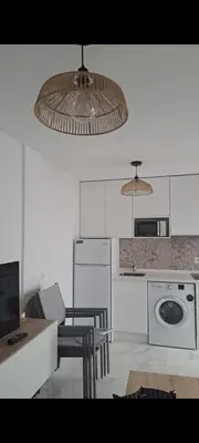 a kitchen with a table and chairs and a microwave at Apartamento la Yedra in Jerez de la Frontera