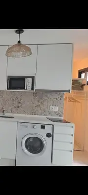 a washing machine in a kitchen with a microwave at Apartamento la Yedra in Jerez de la Frontera