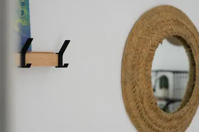 a mirror hanging on a wall next to a vase at Apartamento - Casa Trufa in Conil de la Frontera