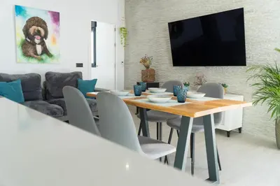 a dining room with a table and chairs and a tv at Apartamento - Casa Trufa in Conil de la Frontera