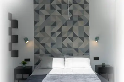 a bedroom with a bed and a geometric wall at Apartamento - Casa Trufa in Conil de la Frontera