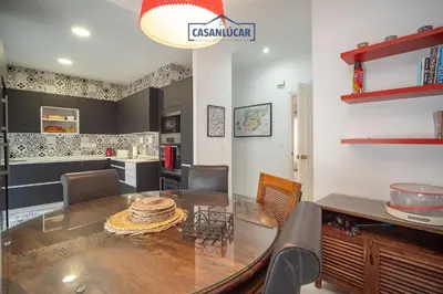 a kitchen and dining room with a table and chairs at Casa 4 - Capuchinos in Sanlúcar de Barrameda