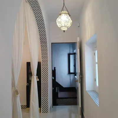 a hallway with a chandelier and a door to a room at Beautiful penthouse with terrace next to the Cathedral in Cádiz