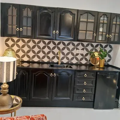 a kitchen with black cabinets and a sink at Beautiful penthouse with terrace next to the Cathedral in Cádiz