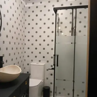 a bathroom with a toilet and a glass shower at Beautiful penthouse with terrace next to the Cathedral in Cádiz