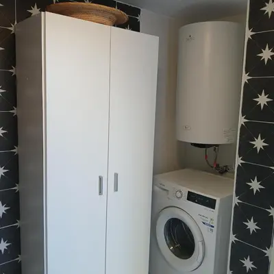 a laundry room with a washing machine and a white cabinet at Beautiful penthouse with terrace next to the Cathedral in Cádiz