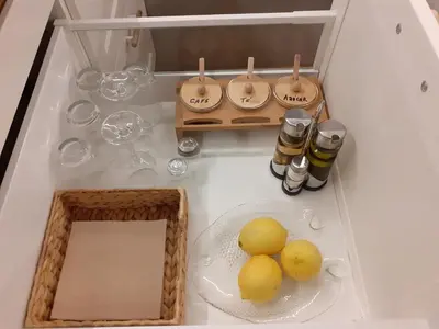 a white counter top with bottles and a plate of food at Casa Flotante El Refugio del Pirata in El Puerto de Santa María
