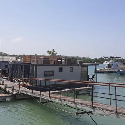 a house boat docked at a dock in the water at Casa Flotante El Refugio del Pirata in El Puerto de Santa María